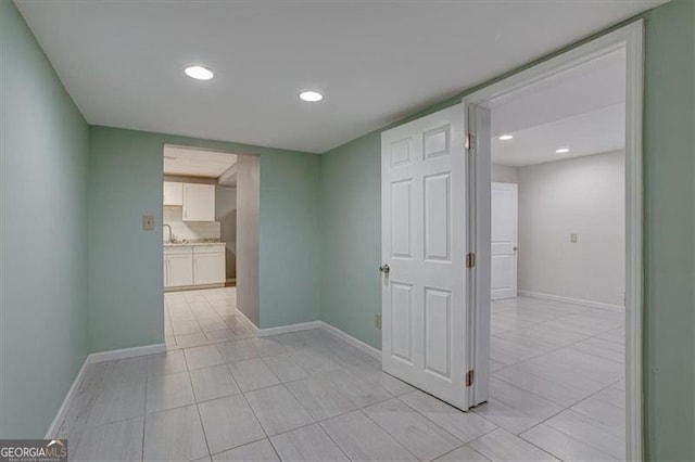 hall featuring sink and light tile patterned floors