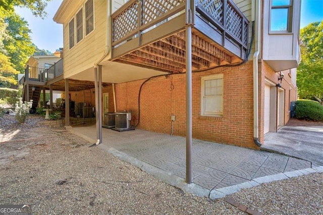 view of side of property with central AC unit, a garage, and a deck