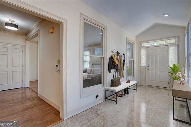 entrance foyer featuring lofted ceiling and ornamental molding