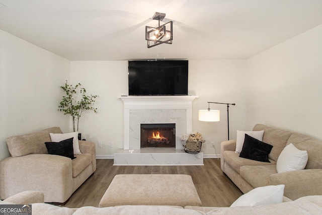 living room with a high end fireplace and hardwood / wood-style floors