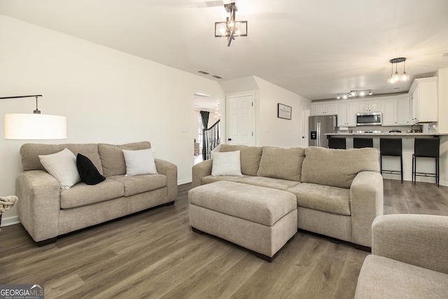 living room with dark hardwood / wood-style flooring and track lighting