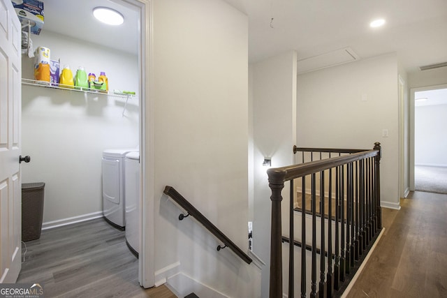 stairs featuring hardwood / wood-style floors and washing machine and clothes dryer