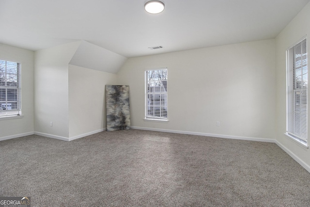 unfurnished living room with vaulted ceiling and carpet