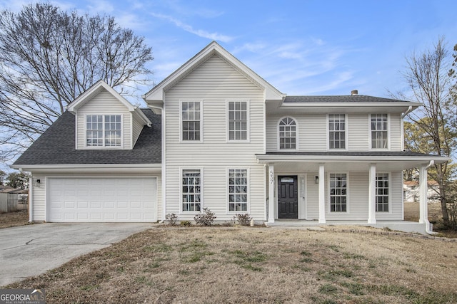 view of front of house with a porch, a garage, and a front lawn