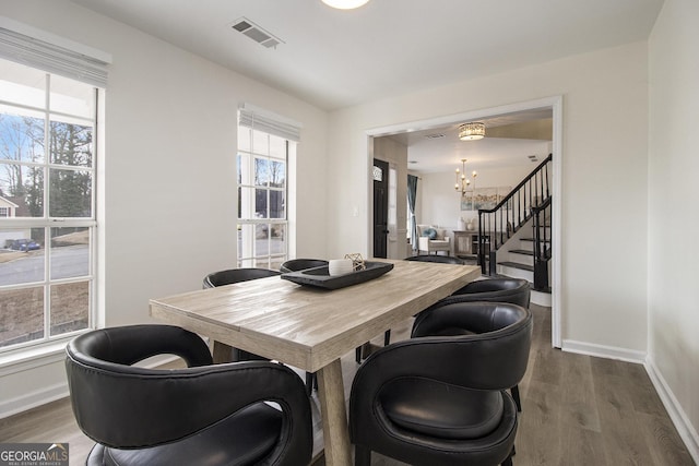 dining area featuring hardwood / wood-style flooring and an inviting chandelier