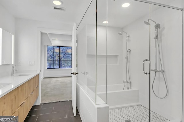 bathroom with tile patterned floors, vanity, and a shower with door