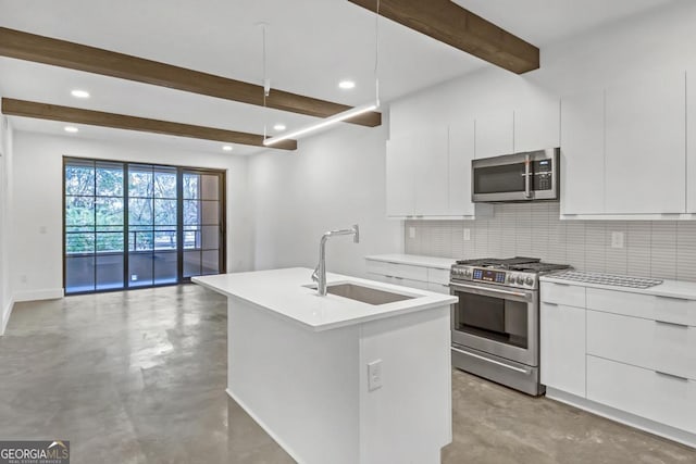 kitchen featuring sink, appliances with stainless steel finishes, a kitchen island with sink, decorative backsplash, and white cabinets