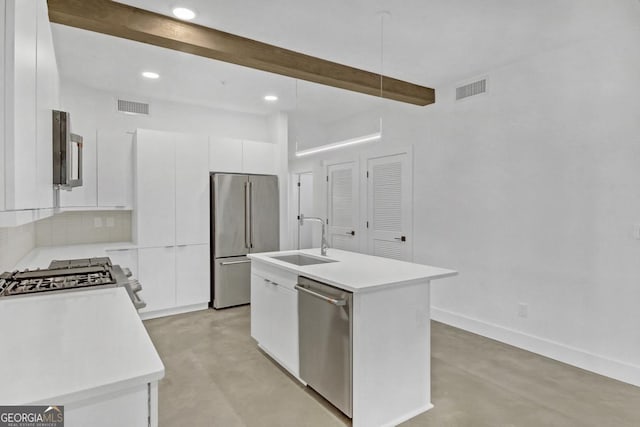 kitchen with sink, white cabinetry, appliances with stainless steel finishes, beamed ceiling, and a kitchen island with sink