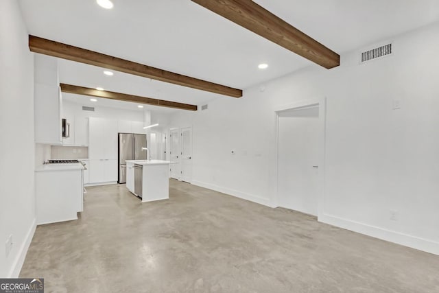 unfurnished living room featuring beam ceiling