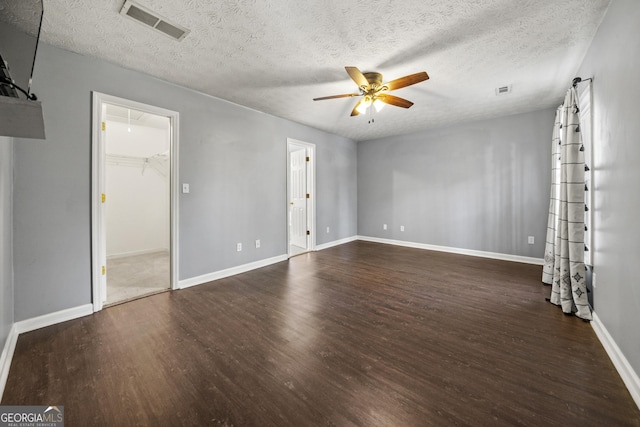 unfurnished room featuring a textured ceiling, dark hardwood / wood-style floors, and ceiling fan