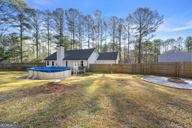 view of yard featuring an outdoor fire pit and a covered pool