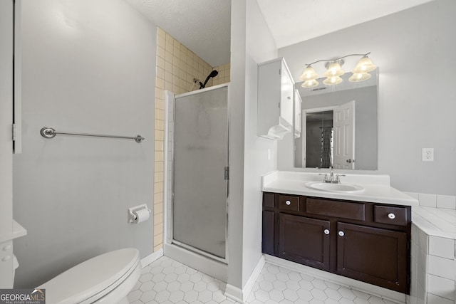 bathroom featuring toilet, a shower with shower door, a textured ceiling, vanity, and tile patterned flooring