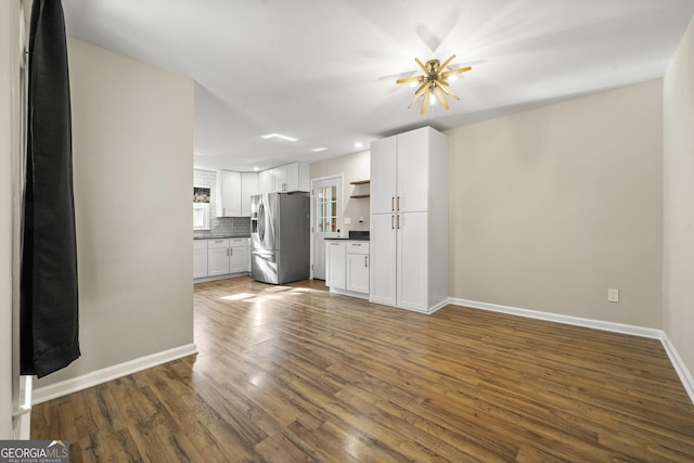 unfurnished living room featuring dark hardwood / wood-style flooring and a notable chandelier