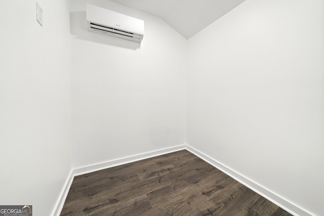 interior space featuring wood-type flooring, lofted ceiling, and a wall mounted AC