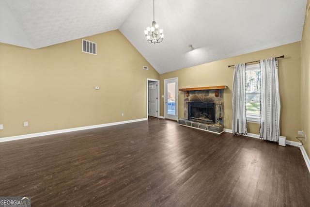 unfurnished living room with a stone fireplace, high vaulted ceiling, dark hardwood / wood-style floors, and a chandelier