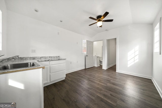 kitchen with white cabinetry, lofted ceiling, sink, ceiling fan, and dark wood-type flooring