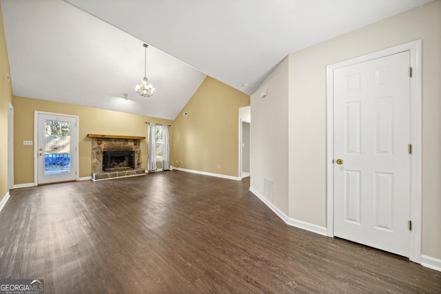 unfurnished living room with a notable chandelier, dark wood-type flooring, a fireplace, and vaulted ceiling