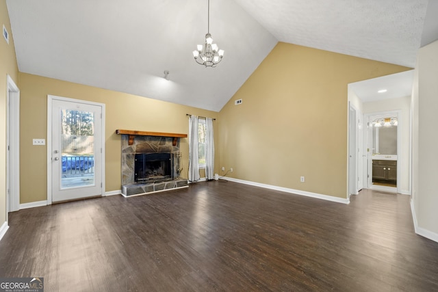 unfurnished living room with dark hardwood / wood-style flooring, a fireplace, high vaulted ceiling, and an inviting chandelier