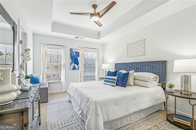 bedroom featuring ceiling fan, carpet flooring, and a raised ceiling