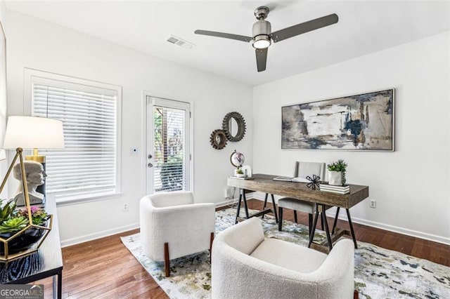 home office with wood-type flooring and ceiling fan