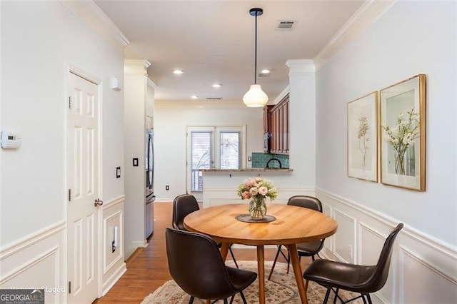 dining area featuring hardwood / wood-style flooring and crown molding