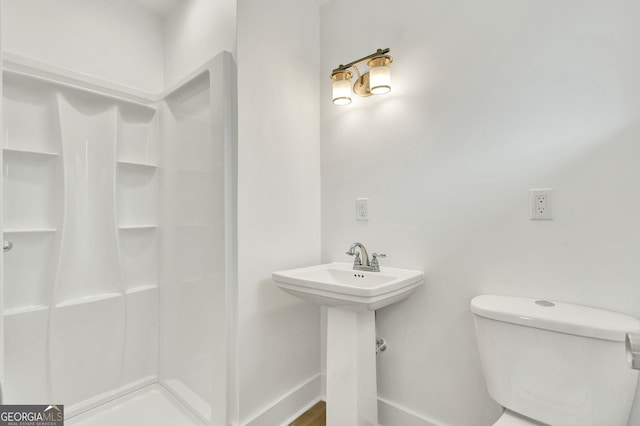 bathroom featuring sink, toilet, and walk in shower