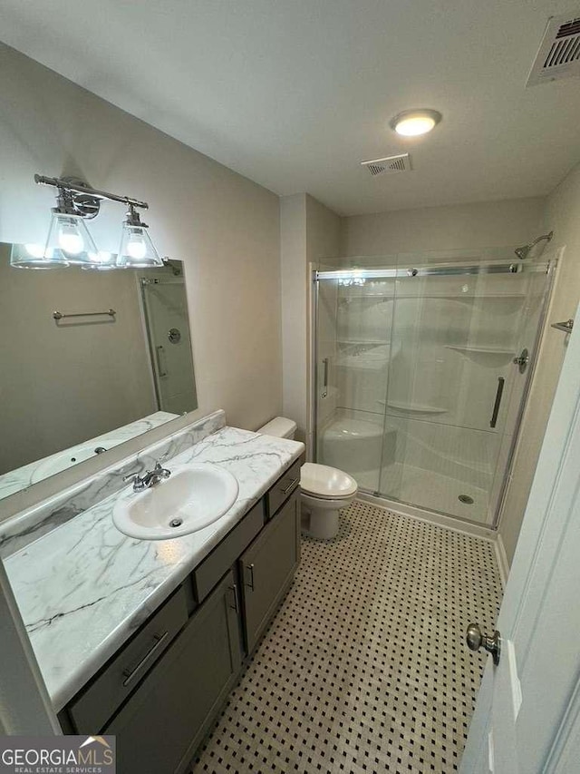 bathroom with an enclosed shower, vanity, and toilet