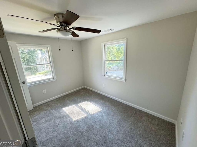 carpeted empty room featuring ceiling fan and a healthy amount of sunlight