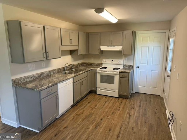 kitchen with white appliances, dark hardwood / wood-style floors, sink, and gray cabinetry