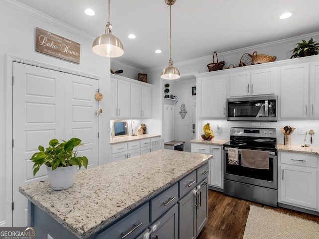 kitchen featuring a kitchen island, decorative light fixtures, white cabinetry, stainless steel appliances, and crown molding