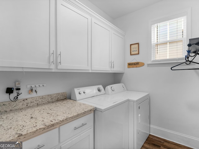 laundry area with dark hardwood / wood-style floors, washer and clothes dryer, and cabinets