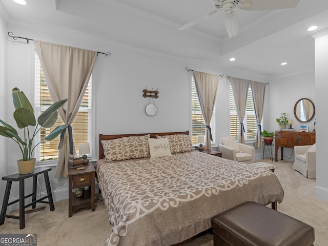 bedroom featuring light colored carpet, ornamental molding, and a raised ceiling