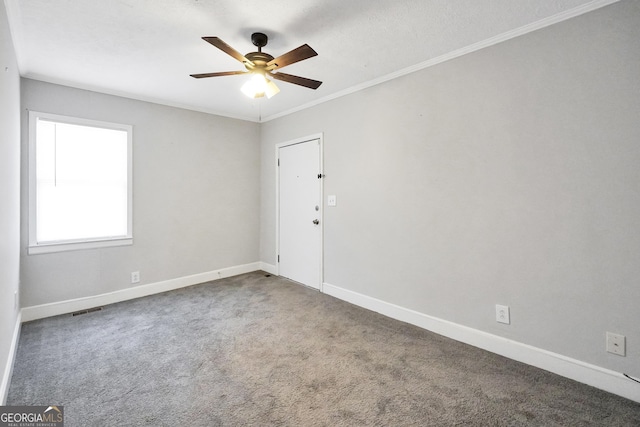 carpeted spare room featuring ornamental molding and ceiling fan