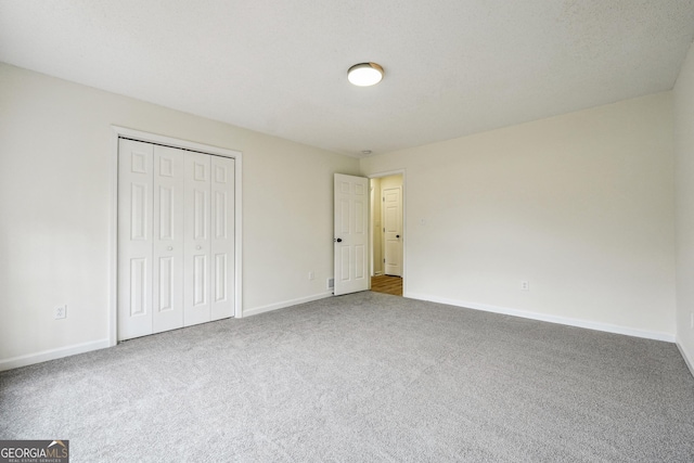 unfurnished bedroom with carpet floors and a closet