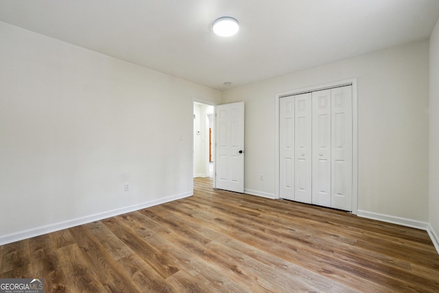 unfurnished bedroom with wood-type flooring and a closet