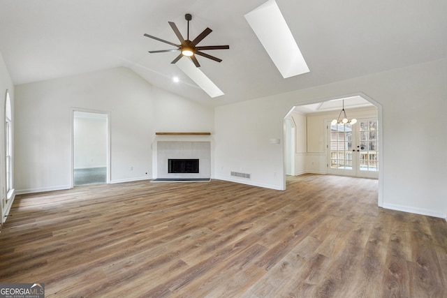 unfurnished living room featuring hardwood / wood-style flooring, vaulted ceiling, and ceiling fan