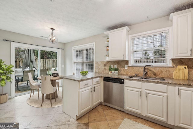 kitchen featuring sink, dark stone countertops, stainless steel dishwasher, kitchen peninsula, and white cabinets