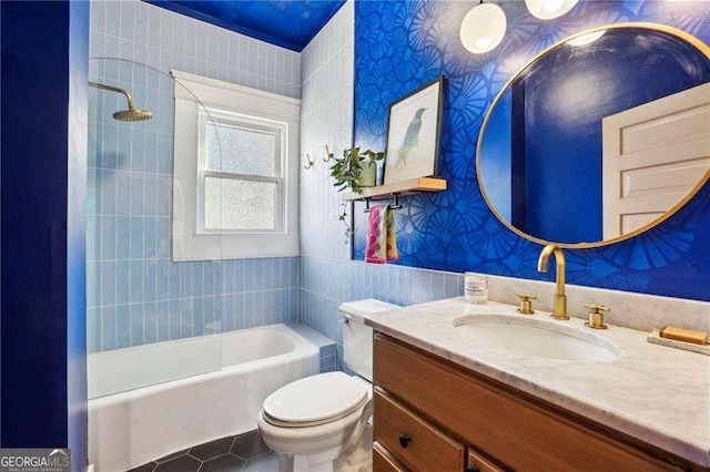 full bathroom featuring tile patterned flooring, tiled shower / bath, vanity, and toilet