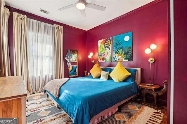 bedroom featuring ceiling fan, ornamental molding, and hardwood / wood-style floors