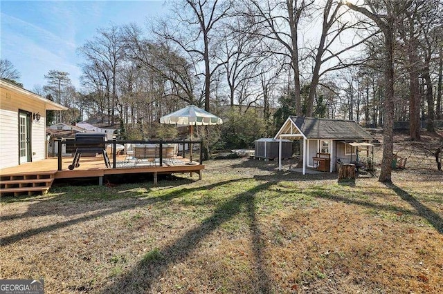 view of yard featuring a wooden deck and a storage shed