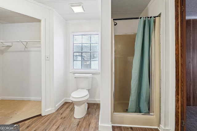 bathroom with hardwood / wood-style floors, toilet, and walk in shower