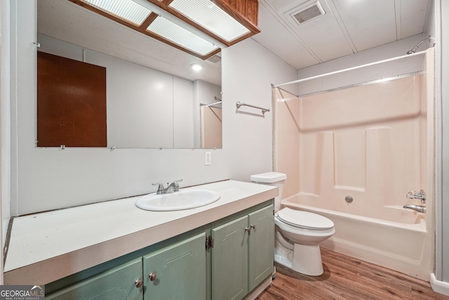 full bathroom featuring vanity, hardwood / wood-style floors,  shower combination, and toilet