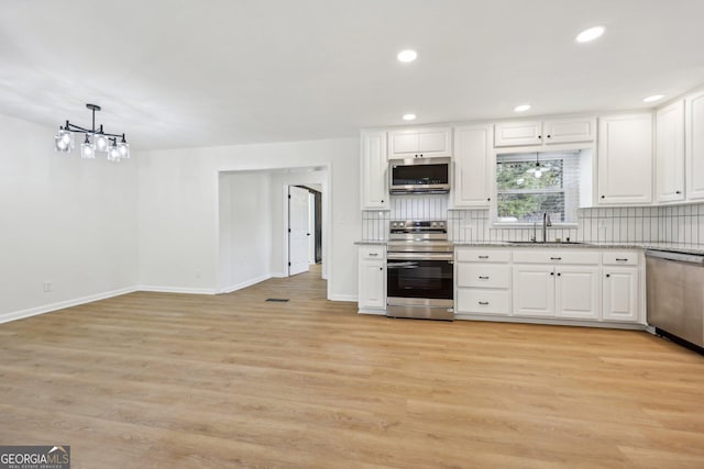 kitchen with white cabinetry, sink, backsplash, and stainless steel appliances