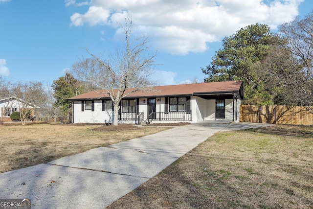 ranch-style house featuring a carport, a porch, and a front yard