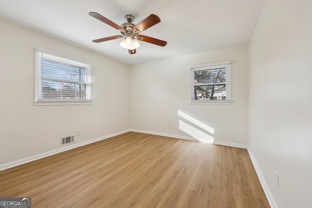 spare room featuring ceiling fan, a healthy amount of sunlight, and light hardwood / wood-style floors