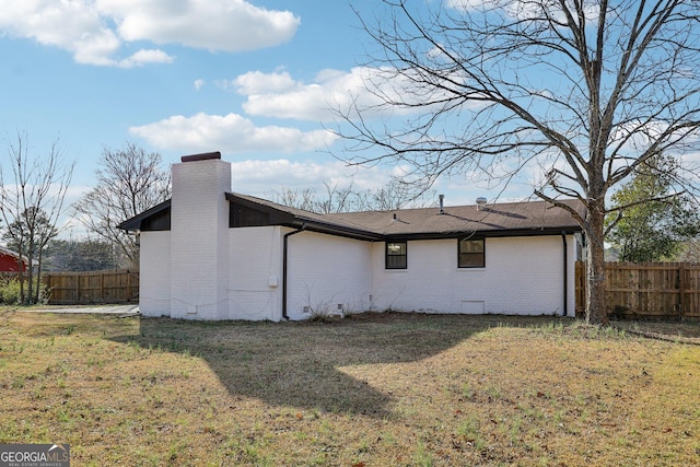 view of side of home with a yard