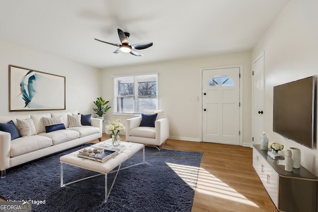 living room with ceiling fan and light hardwood / wood-style flooring