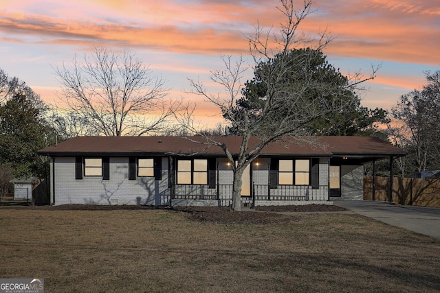 single story home featuring a carport and a lawn