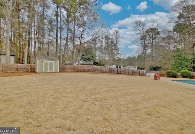 view of yard with a storage shed and a fenced in pool