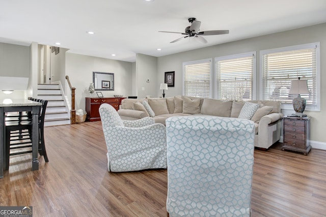 living room featuring wood-type flooring and ceiling fan